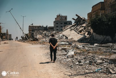 A Man Walks Beside Destroyed Buildings In Gaza Photo Credit Caritas Jerusalem