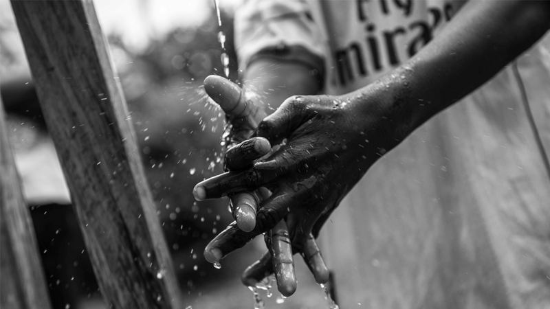 child washing hands in water