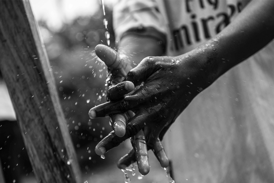 child washing hands in water