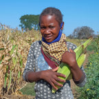 Anatercia carries corn next to her fields in Mozambique