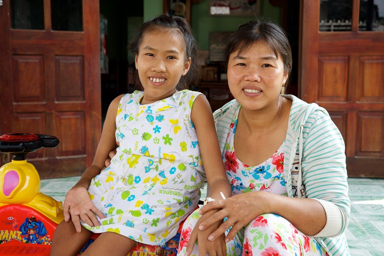Nguyet (left) from Vietnam was born with cerebral palsy causing paraplegia of her legs and one hand and as a result has been unable to attend school. Nguyet and her family have been part of the Capacity Building for Parent Associations for Children with Disabilities program run by Caritas Australia partner Catholic Relief Services since 2014. Photo credit: Richard Wainwright/Caritas Australia.