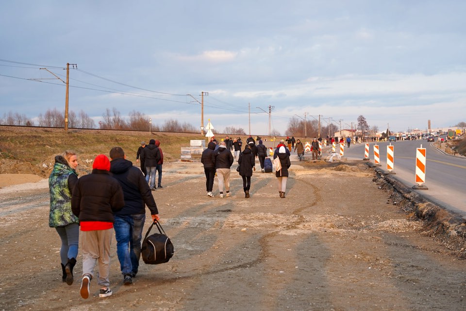 Ukrainian refugees fleeing to safety at Ukraine-Poland border.