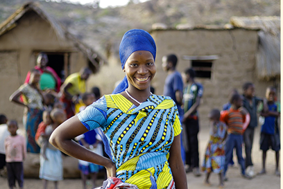 Oliva stands near her home in Karatu District, Tanzania