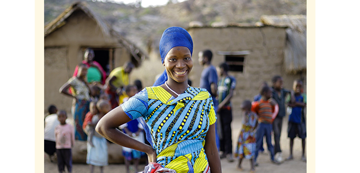 Oliva stands near her home in Karatu District, Tanzania