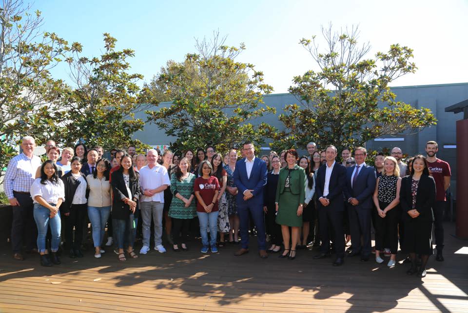 Minister with NGO staff in courtyard in Australia