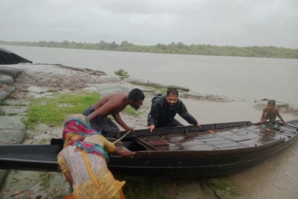 People load into a raft to escape from rising waters. Photo: Caritas Bangladesh