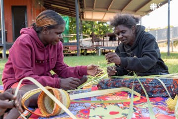 Mother and daughter weaving together