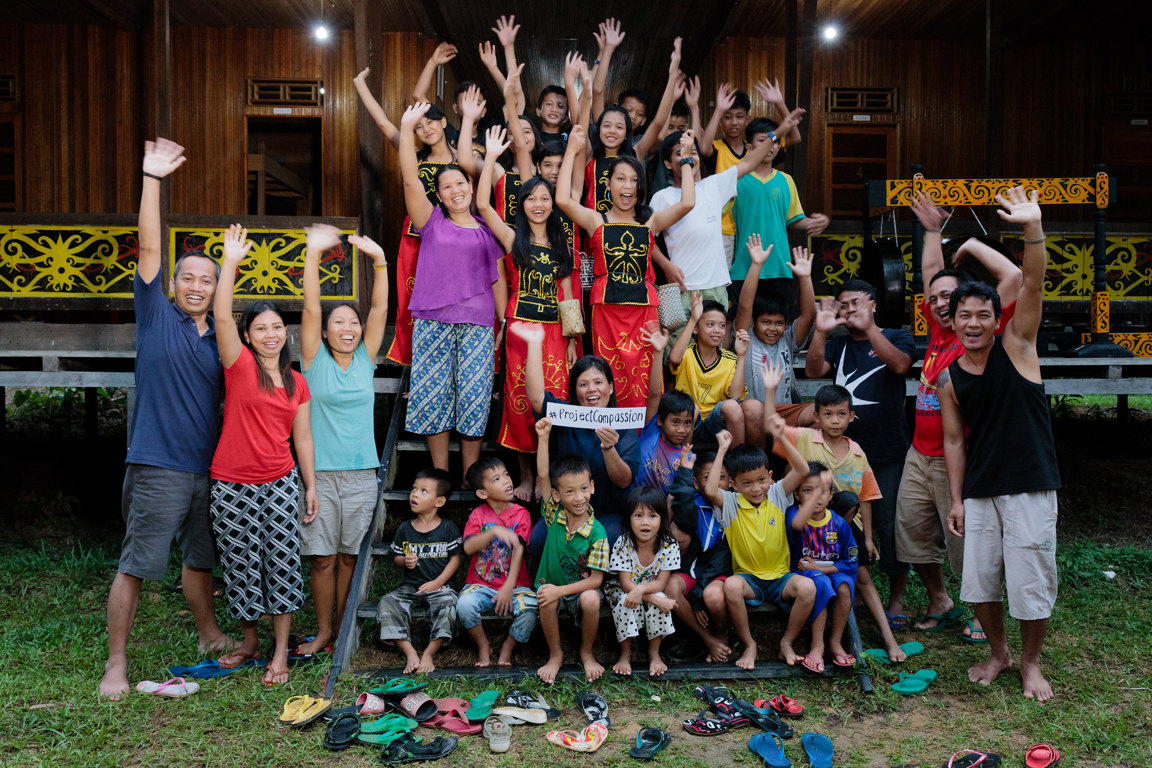 Group of people waving outside house in Indonesia